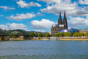 Cologne, Germany - July 9. 2022: View over river rhine on gothic dom towers, Hhohenzollern bridge, musical dome in summer