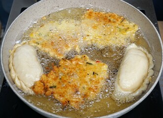 Bratende asiatische Gemüsepfannkuchen in weißer Pfanne mit heißem Fett auf Herdplatte 