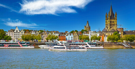 Cologne, Germany - July 9. 2022: Beautiful panoramic rhine river skyline, St. Martin church, cruise ships, colorful medieval waterfront houses - obrazy, fototapety, plakaty
