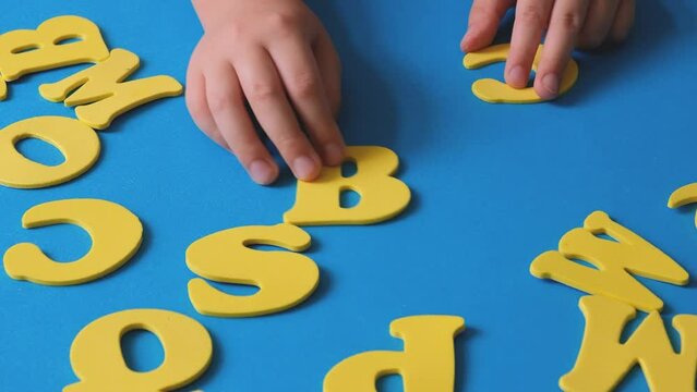 Child's hand playing with letters of the alphabet