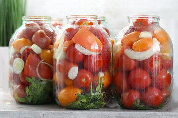 Homemade Preservation: Large glass jar with red ripe pickled tomatoes. Pickles for the winter.