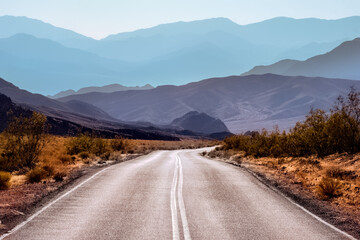 Fototapeta premium Lonely desert road winding away into distant mountains