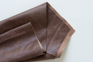 folded brown leather object with triangle edge