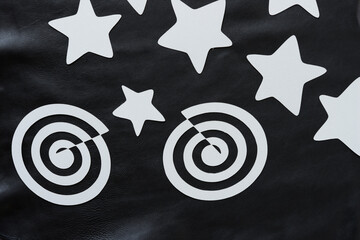 paper stars and swirls on black leather