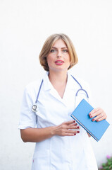 Fototapeta premium Young beautiful caucasian woman doctor with a phonendoscope on her neck 