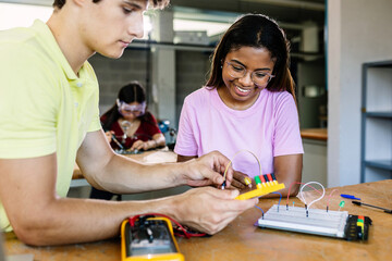 Diverse young school students learning electronic circuits at technology class - Education tech concept