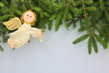 Christmas decoration with green branches and textil angel on a white background