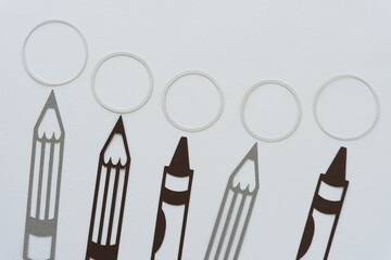 writing instruments (pencil and crayon) silhouettes with paper rings or circles on blank paper