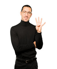 Naklejka premium Young man making a number four gesture