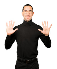 Fototapeta premium Young man making a number ten gesture