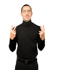 Fototapeta premium Happy young man making a victory gesture with his fingers