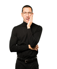 Concerned young man with a toothache gesture