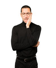 Concerned young man with a toothache gesture