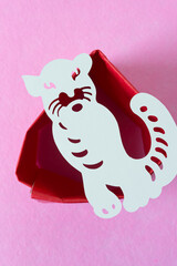 stylized white tiger glyph isolated on folded red tissue paper and pink felt