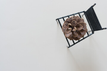 metallic high back chair on blank paper with pine cone
