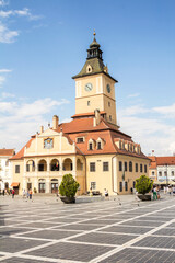 Fototapeta na wymiar Brasov, Romania, the central square of the city of Brasov, the old ranotsny square, tower with hours in the center - Aug 2022