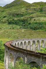 Obraz premium Glenfinnan Viaduct,vertical profile, amongst summertime Scottish Highland scenery,Glenfinnan, Scotland, UK.