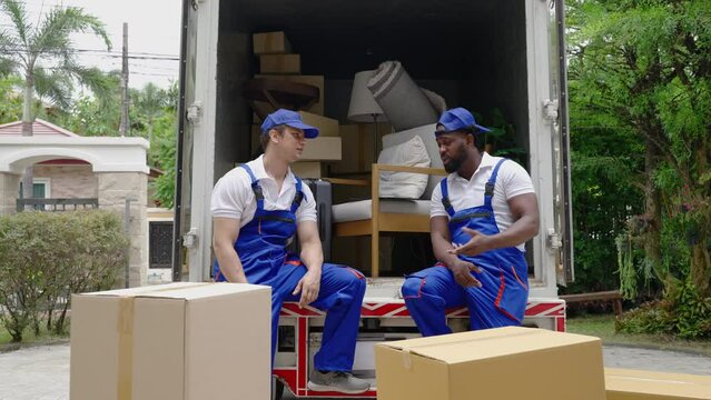  moving company employee sits and waits for the owner to open the door to unload the truck into the new home.
