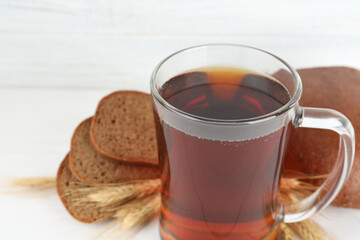 Mug of delicious kvass on white table, closeup