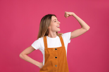 Strong woman as symbol of girl power on pink background. 8 March concept