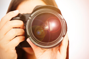 Photographer with professional camera on light background, closeup