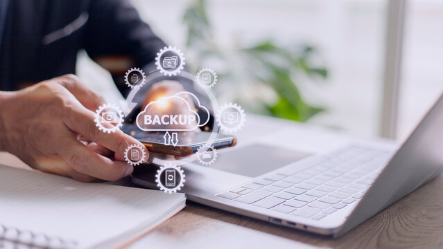 Mobile phone synchronizing data with a computer for backup over a wireless connection with a hand holding smartphone