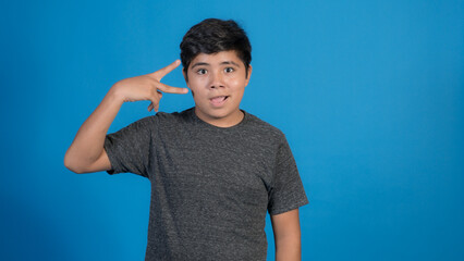 Foto de chico alegre llevar ropa de moda haciendo aislada en el fondo de color azul. Haciendo...