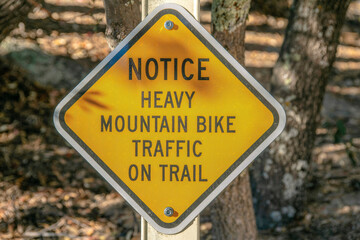Mount Lemmon, Arizona- Diagonal yellow signage with Notice Heavy Mountain Bike Traffic on Trail
