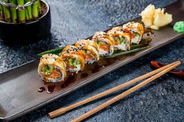 roll Canada with eel, salmon and avocado on dark stone table