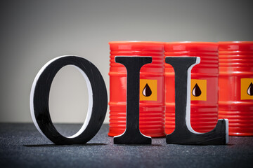  word OIL and barrels with crude oil on grey background.