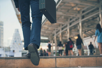 Businessman walking with luggage in business trip. Focus on man legs boarding travel arrival terminal. Business travel trip holding suitcase at airport. Young business man traveller concept