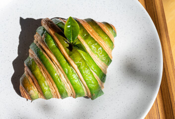 High angle view of Matcha (or green tea) croissant served with plate on wooden table. Croissant is...