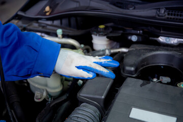 Closeup hands of man is mechanic repairing engine of car in the garage, auto service, worker fix and adjusting part of automobile with problems in the station, transportation and automotive concept.