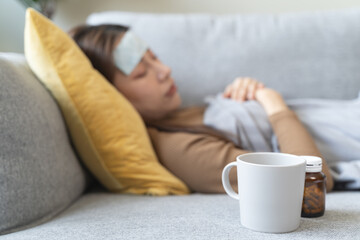 Sick at home. Asian woman has fever sleep on sofa at home during quarantine virus.