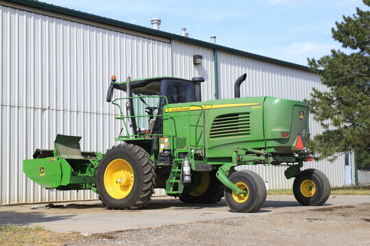 John Deere Swather in a drive way with sky