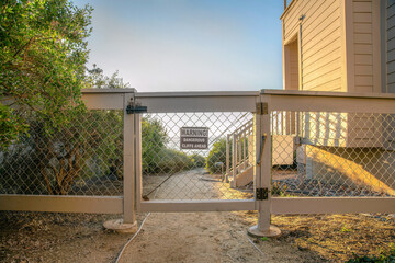 La Jolla, California- Gate and fence with mesh wire and signage with warning