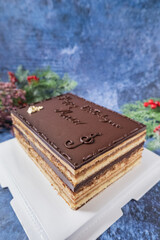 Opera cake on white cake board and blue background 