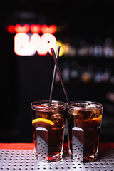 Two glasses with whiskey and cola cocktail in a nightclub bar. Night life, club life. Great serving of cocktails