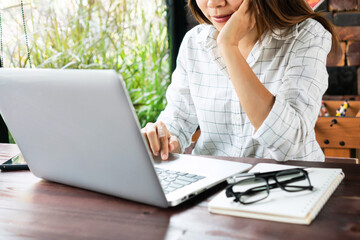 Closeup of young Asian women freelancer working on laptop while sitting at home. Business, technology and lifestyle, work at home concept.