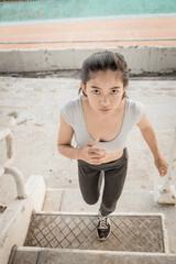 Young strong fit woman showing bicepses portrait in gym, looking away