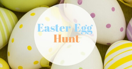 Close-up of easter egg hunt text over multi colored spotted and striped eggs