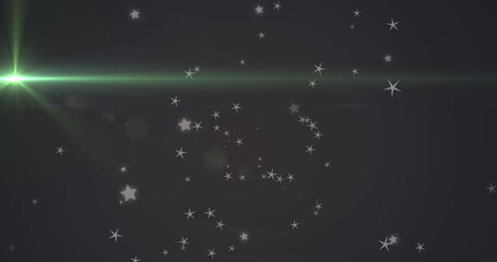 Fototapeta premium Image of glowing green light moving over stars in background