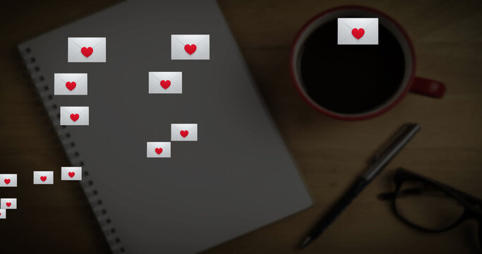 Multiple envelope with heart icon floating against book, coffee cup and glasses on wooden surface