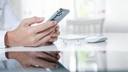 Closeup man hand using mobile phone at home. Technology device communication connecting.