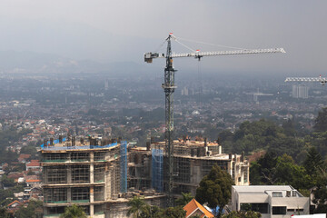 Aerial view of construction site with tower cranes during construct the high-rise building. Cranes at the pouring concrete into the formwork. 