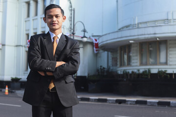 Successful businessman portrait with arms crossed smiling happy at the city. 