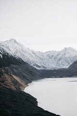 Mt Cook landscape viewed from Tasman Lake with iceberg floating in water. Tasman Lake created by the melting Tasman Glacier in Mount Cook National Park, New Zealand South Island.