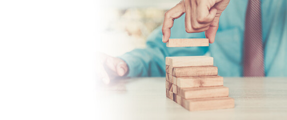 Close-up hand prevent wooden block not falling domino concepts of financial risk management and...