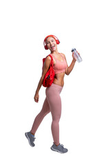 Full body length shot of smiling young sporty Asian woman fitness model in pink sportswear with headphone holding red sports bag and water. Fitness and healthy lifestyle concept.