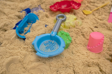 Fototapeta na wymiar Children's sandbox with plastic toys, concept of summer games in the sand